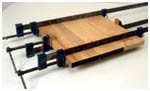 Clamps are positioned alternatively under and over the workpiece to minimize distortion when pressure is applied